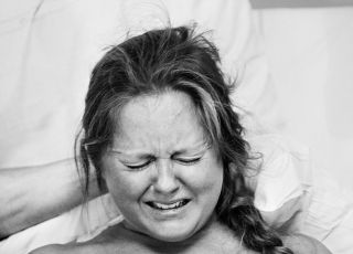 Czarno-biała fotografia twarzy rodzącej kobiety.