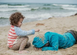 dzieci bawią się na wietrznej plaży