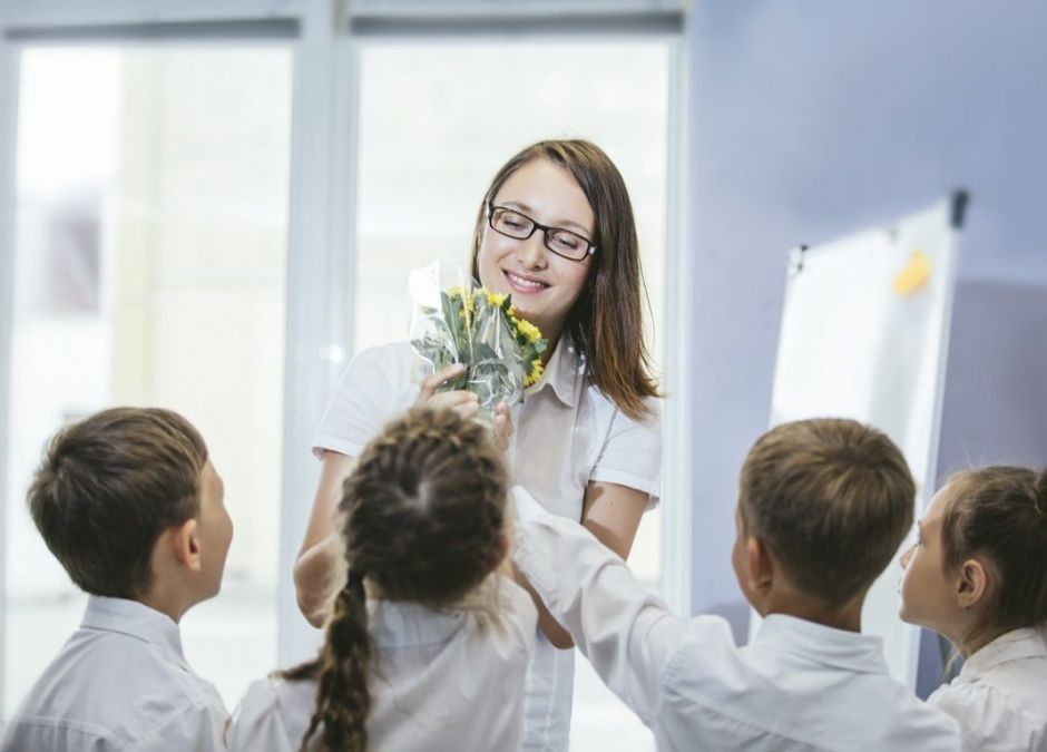 dzieci dają kwiaty ulubionej nauczycielce