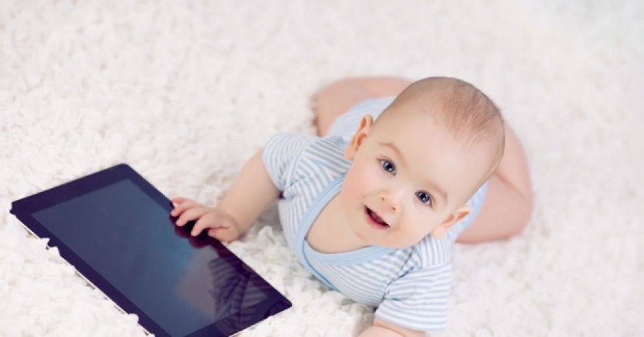 dziecko z tabletem na dywanie