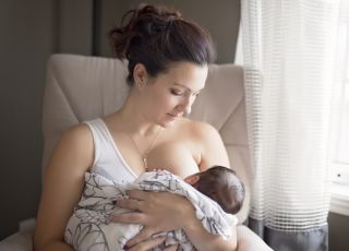 kobieta karmi piersią nowo narodzone dziecko