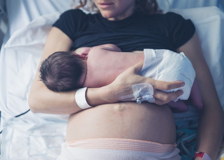 kobieta karmi piersią nowo narodzonego maluszka w szpitalu