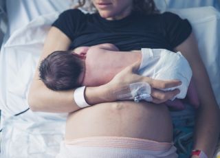 kobieta karmi piersią nowo narodzonego maluszka w szpitalu