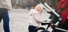 małe dziecko idzie trzymając się wózka