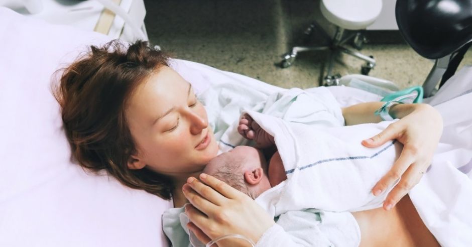 Młoda mama na porodówce z noworodkiem