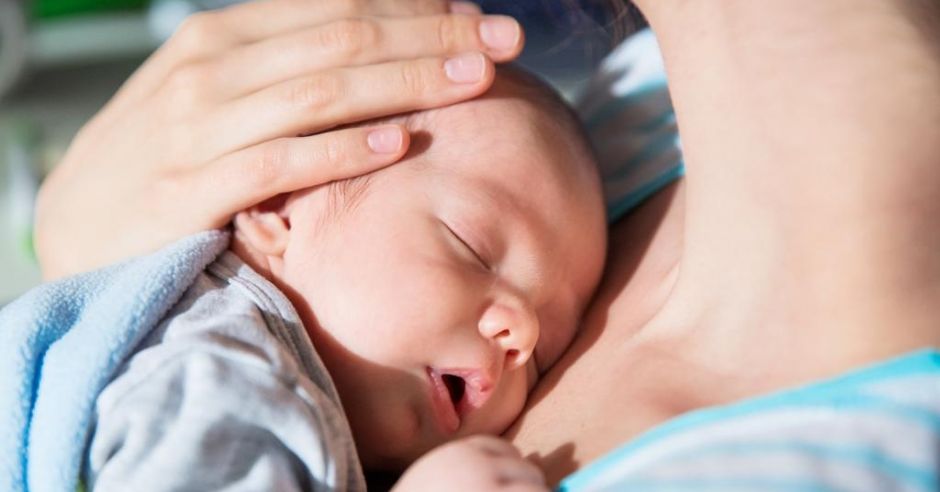 Niemowlę śpi u mamy na rękach