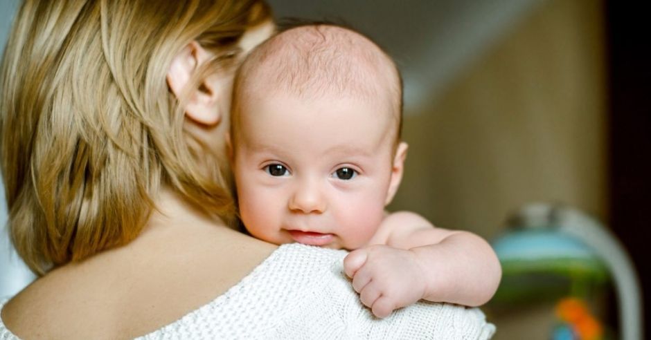 Niepracująca mama trzyma w ramionach niemowlę