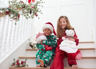uśmiechnięte dzieci siedzą na schodach przed Świętami