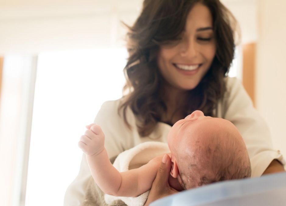 wyprawka dla noworodka - mama kąpie dziecko